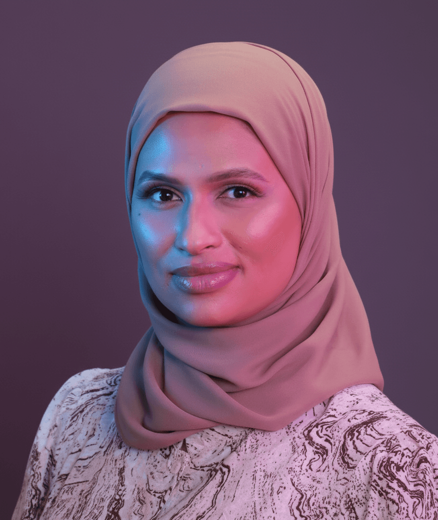 Habiba speaking on a panel, holding a microphone.